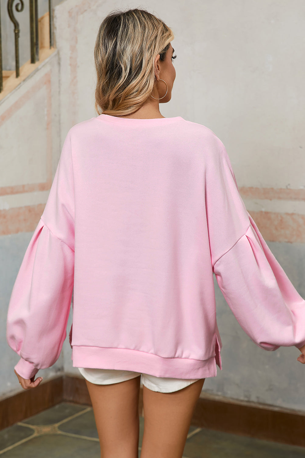 Feminine light pink sweatshirt with bow lantern sleeves.