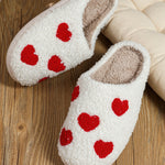 Soft plush slippers with white heart design for warmth and comfort