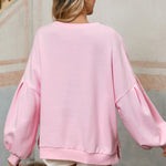 Feminine light pink sweatshirt with bow lantern sleeves.
