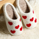 Soft plush slippers with white heart design for warmth and comfort
